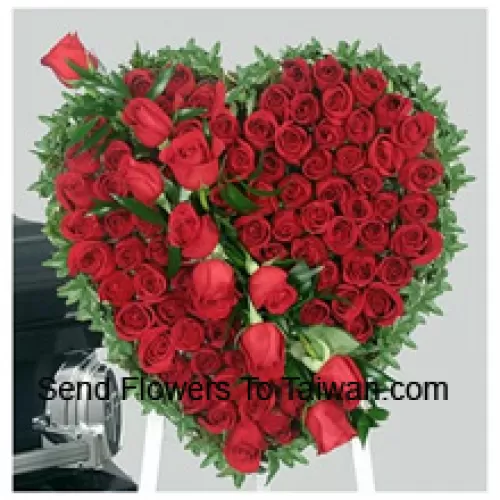 Un beau arrangement en forme de cœur de 100 roses rouges