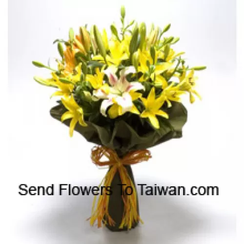 Un gros bouquet de lys jaunes et blancs avec des remplissages saisonniers