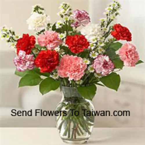 12 Mixed Colored Carnations With Some Ferns In A Glass Vase
