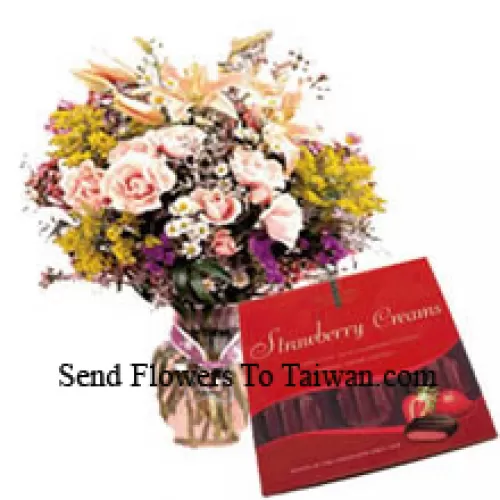 Gemischte Blumen in einer Vase und eine Schachtel Schokolade